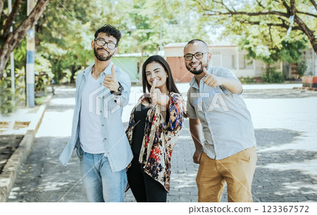 Three happy friends giving thumbs up on the street. Three smiling teenagers giving thumbs up on the street. Team concept of smiling friends giving thumbs up on the street Three happy friends giving thumbs up on the street. Three smiling teenagers giving thumbs up on the street. Team concept of smiling friends giving thumbs up on the street 123367572