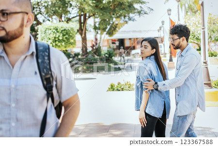 Unfaithful girl looking at another man on street while her boyfriend claims her. Disloyal girlfriend looking at another guy on the street. Unfaithful girlfriend looking at another man on the street Unfaithful girl looking at another man on street while her boyfriend claims her. Disloyal girlfriend looking at another guy on the street. Unfaithful girlfriend looking at another man on the street 123367588
