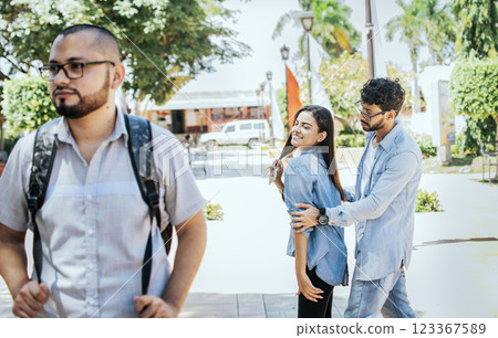 Disloyal girlfriend looking at another guy on the street. Unfaithful girlfriend looking at another man on the street, Unfaithful girl looking at another man on street and her boyfriend claims her 123367589