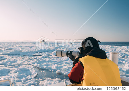 Drift ice and a photographer photographing it from a ship 123368462