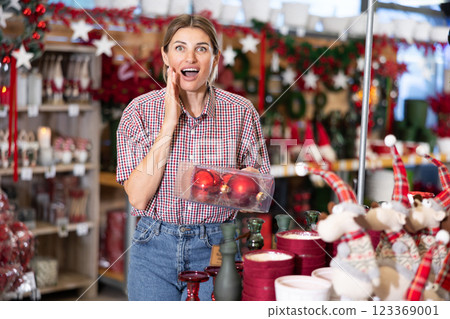 Adult woman choosing christmas decorations in store Adult woman choosing christmas decorations in store 123369001