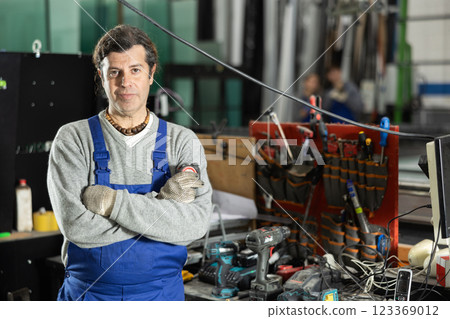 Adult man with tape measure in workshop Adult man with tape measure in workshop 123369012