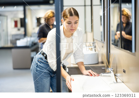 Confident female customer choosing bathroom sink in hardware store Confident female customer choosing bathroom sink in hardware store 123369311