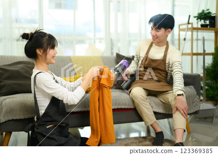 Happy young couple cleaning and organizing their home Happy young couple cleaning and organizing their home 123369385