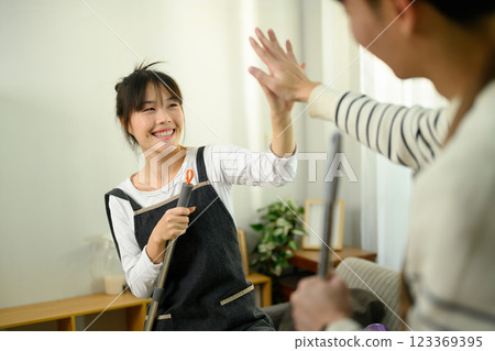 Cheerful young couple gives each other high five celebrating a successful cleaning day Cheerful young couple gives each other high five celebrating a successful cleaning day 123369395