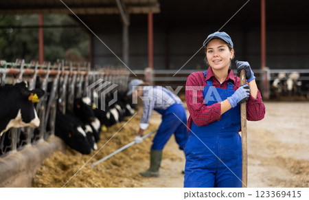 Farmer woman stands with rake at cow farm 123369415