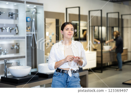 Confident female customer looking around in bathroom section of hardware store 123369497