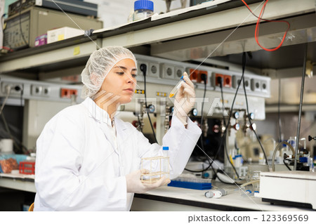 Focused female technician working in research laboratory Focused female technician working in research laboratory 123369569