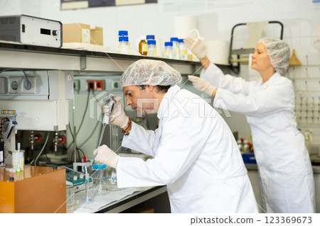 Man and woman scientists chemists conduct experiments in the laboratory Man and woman scientists chemists conduct experiments in the laboratory 123369673
