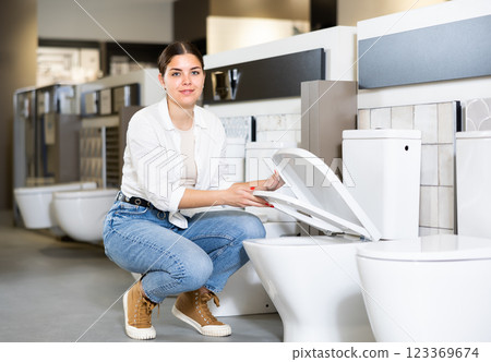 Confident female customer choosing new toilet in hardware store Confident female customer choosing new toilet in hardware store 123369674