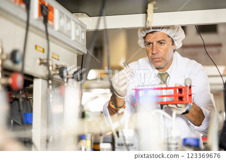 Focused man technician working in research laboratory Focused man technician working in research laboratory 123369676