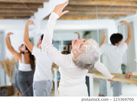 Women and men training in ballet class with other dancers in studio 123369700