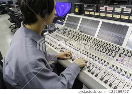 Staff working in the audio booth of a TV station's control room. Filming cooperation: SKY Perfect TV Tokyo Media Center Staff working in the audio booth of a TV station's control room. Filming cooperation: SKY Perfect TV Tokyo Media Center 123369737
