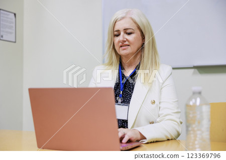 A middle-aged white woman with gray hair working on a computer 123369796