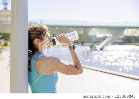 女人在公園裡跑著喝水 123369843