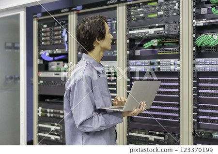 A young man working in front of the equipment in a TV station's control room. Filming courtesy of Sky Perfect TV Tokyo Media Center 123370199