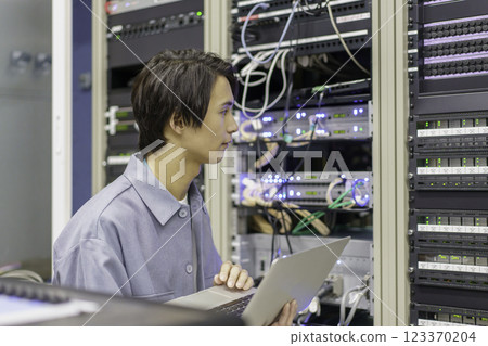 A young man working in front of the equipment in a TV station's control room. Filming courtesy of Sky Perfect TV Tokyo Media Center 123370204