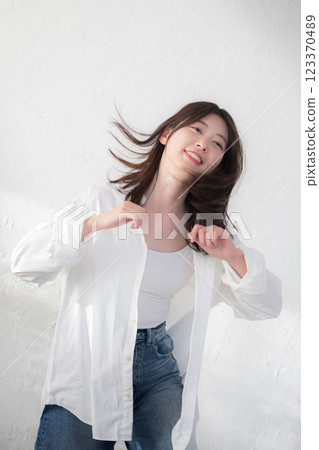 一個穿著牛仔布、在白色背景上跳舞的可愛女人的全身 123370489
