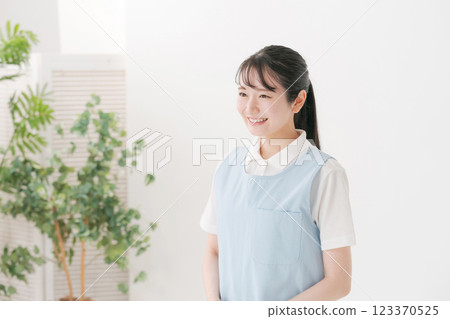 A caregiver in his 20s wearing an apron 123370525