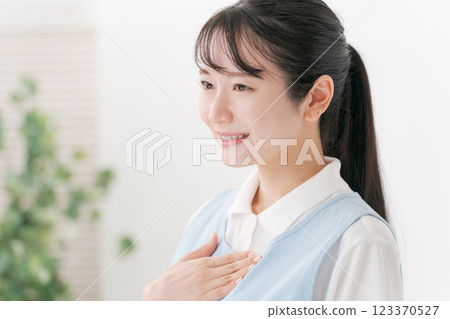 一名 20 多歲、身穿圍裙的護理人員 一名 20 多歲、身穿圍裙的護理人員 123370527