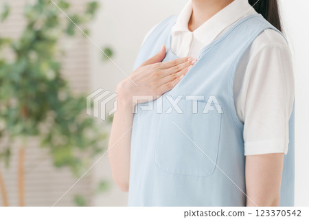 A caregiver in his 20s wearing an apron 123370542