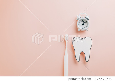 Dentist Day highlights. Paper tooth, toothbrush, and white alarm clock on pink background Dentist Day highlights. Paper tooth, toothbrush, and white alarm clock on pink background 123370670