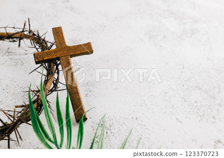 Palm Sunday setup with wooden cross, crown of thorns, and palm leaves on gray Palm Sunday setup with wooden cross, crown of thorns, and palm leaves on gray 123370723