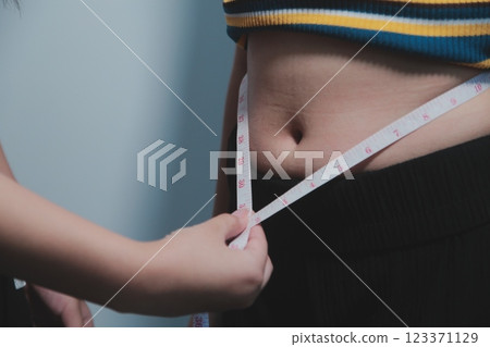 Women body fat belly. Obese woman hand holding excessive belly fat. diet lifestyle concept to reduce belly and shape up healthy stomach muscle. Women body fat belly. Obese woman hand holding excessive belly fat. diet lifestyle concept to reduce belly and shape up healthy stomach muscle. 123371129