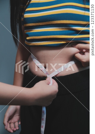 Women body fat belly. Obese woman hand holding excessive belly fat. diet lifestyle concept to reduce belly and shape up healthy stomach muscle. Women body fat belly. Obese woman hand holding excessive belly fat. diet lifestyle concept to reduce belly and shape up healthy stomach muscle. 123371130