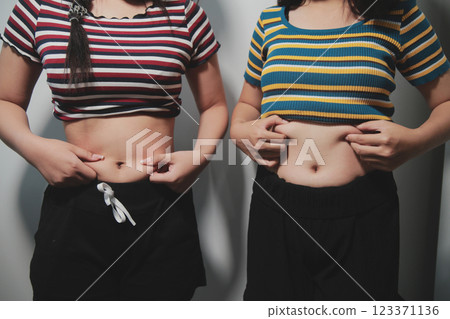 Women body fat belly. Obese woman hand holding excessive belly fat. diet lifestyle concept to reduce belly and shape up healthy stomach muscle. 123371136