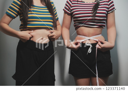 Women body fat belly. Obese woman hand holding excessive belly fat. diet lifestyle concept to reduce belly and shape up healthy stomach muscle. Women body fat belly. Obese woman hand holding excessive belly fat. diet lifestyle concept to reduce belly and shape up healthy stomach muscle. 123371140