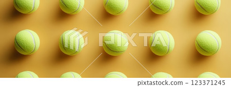 Multiple tennis balls are arranged in a grid pattern on a vibrant yellow backdrop, creating a visually appealing and sporty composition Multiple tennis balls are arranged in a grid pattern on a vibrant yellow backdrop, creating a visually appealing and sporty composition 123371245