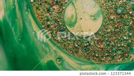 Acrylic blob. Paint mix. Shimmering metal particles gel drop floating in green water. Abstract defocused moisture bubble burst background. Acrylic blob. Paint mix. Shimmering metal particles gel drop floating in green water. Abstract defocused moisture bubble burst background. 123371344