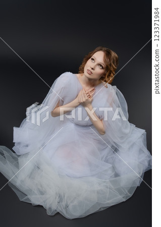 Elegant woman in white lingerie inspired bridal attire with flowing fabric 123371984