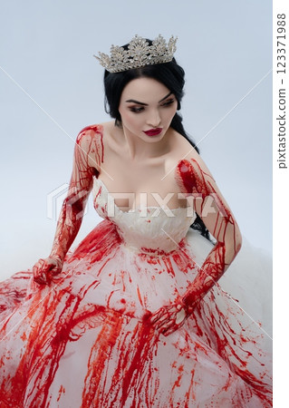 Bride in blood-stained dress portrays beauty and horror with knife Bride in blood-stained dress portrays beauty and horror with knife 123371988