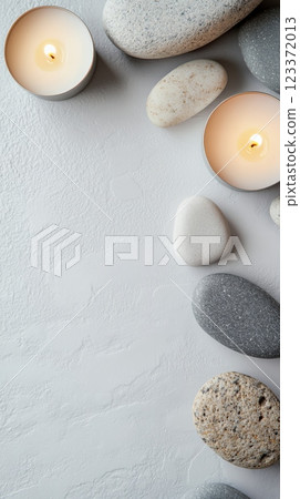 Burning aromatherapy candles and spa stones are lying on a white textured background, creating a relaxing and peaceful atmosphere Burning aromatherapy candles and spa stones are lying on a white textured background, creating a relaxing and peaceful atmosphere 123372013