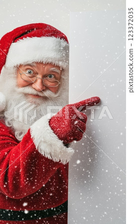 Santa Claus pointing at a blank snowy sign, ideal for custom Christmas messages, festive holiday template. 123372035