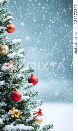 Close-up view of a Christmas tree decorated with golden and red baubles under falling snow, ideal for festive backgrounds. 123372201