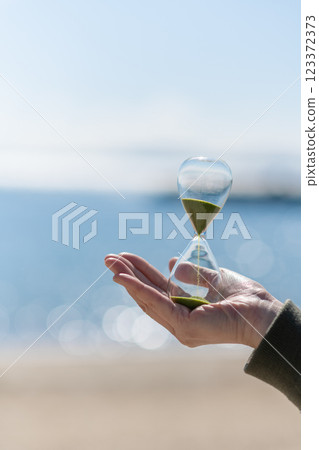 海灘上拿著沙漏的人 123372373