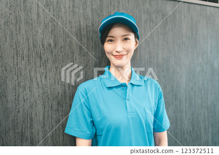 Female staff wearing blue polo shirt and hat 123372511