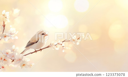 Small bird perched on a flowering tree branch enjoying springtime with soft focus background and bokeh effect, evoking feelings of peace, tranquility, and renewal 123373078