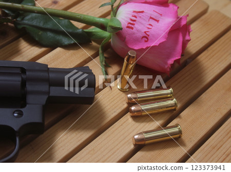 Vintage Gun With Bullets and Rose. Revolver and Ammunition Vintage Gun With Bullets and Rose. Revolver and Ammunition 123373941