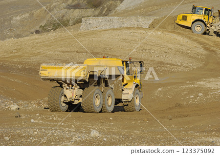 Yellow dump truck working in gravel pit Yellow dump truck working in gravel pit 123375092