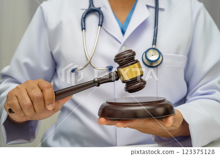 Doctor holding judge gavel, forensic medicine, medical law and crime justice. 123375128