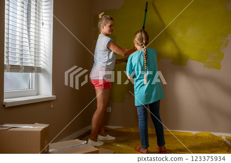 A Mother and Her Daughter Joyfully Engaged in Painting Together in a Bright and Cheerful Room 123375934