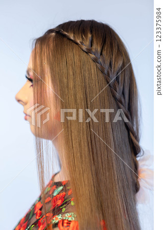 An Elegant and Stylish Side Profile Hairstyle Featuring Beautiful Braids and a Floral Dress 123375984