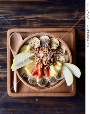 Smoothie bowl with bananas, berries, granola and other ingredients 123375987