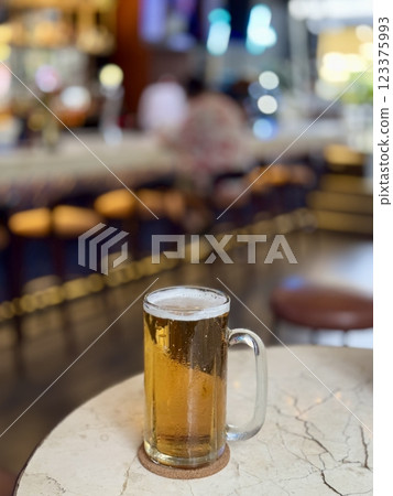 A glass of light beer is on the table 123375993