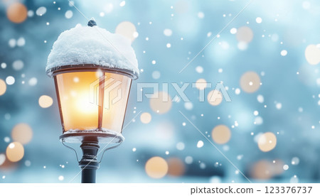 streetlamp covered in snow glows softly amidst falling snowflakes, creating serene winter scene 123376737