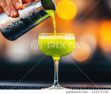 Refreshing green drink being poured into stylish glass 123377150